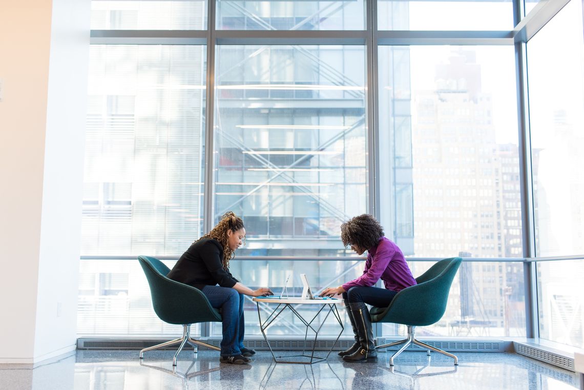 Two ladies sitting across each other in a meeting